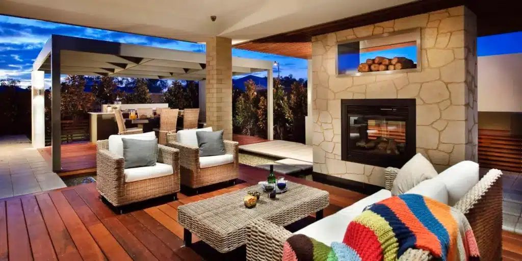 Covered alfresco with a stone fireplace and lounge seating