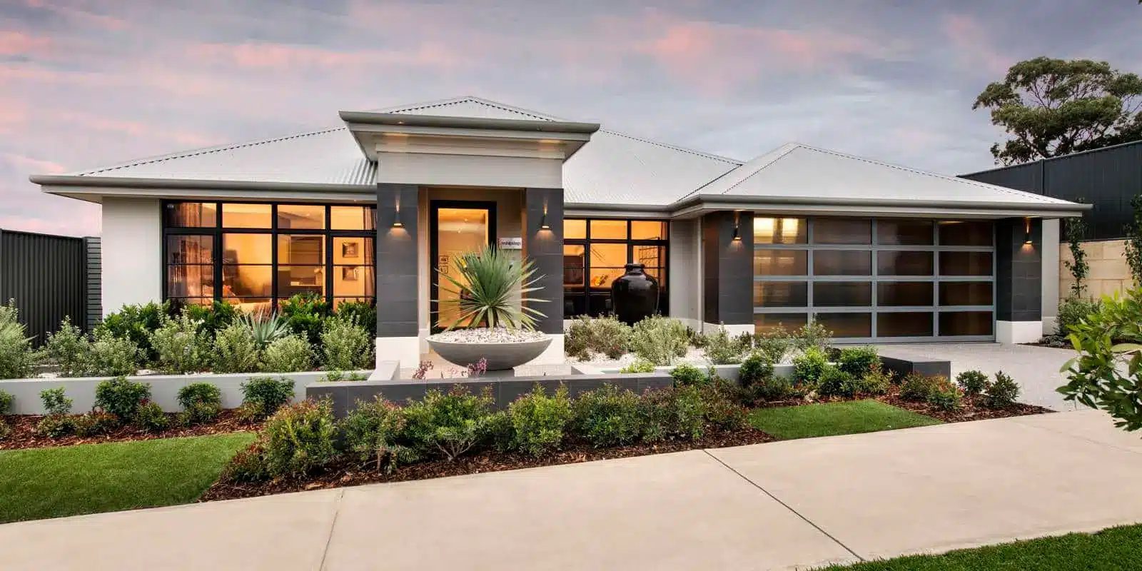 Single storey home with a finished front garden, lawn and water feature